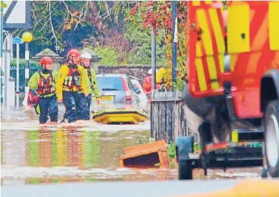 Emergency service workers check on residents after severe flooding in Monmouth, South Wales, on Saturday. Nearly 12 centimetres of rain fell overnight in southeast Wales.