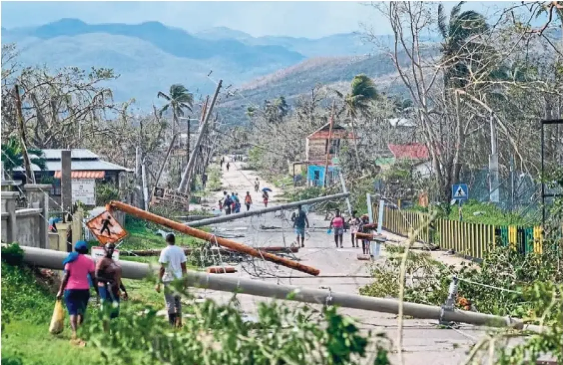 Residents walk through Lacovia Tombstone, Jamaica, in the aftermath of Hurricane Melissa on Wednesday. More than 77 per cent of the country is now without electricity and more than 25,000 people are in shelters across the island, authorities said.