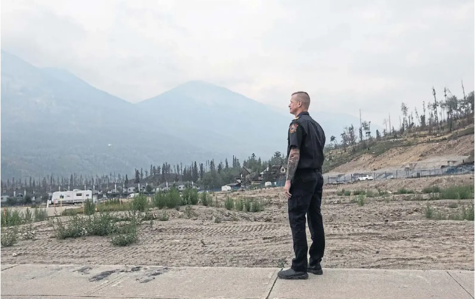 Jasper
Fire Chief Mathew Conte stands in the firestricken town Monday. A year after wildfires swept through the area, the community is slowly rebuilding what it lost.