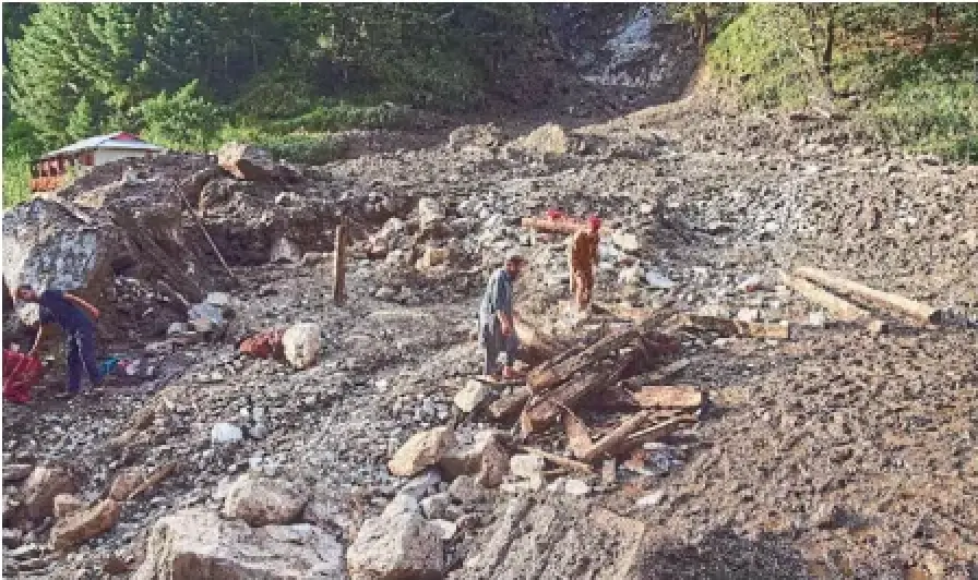 Villagers collect wood and other items from the debris of damaged houses at the site of a cloudburst that triggered a flash flood, in Naryan Behak village near Muzaffarabad, Kashmir, on Friday.
