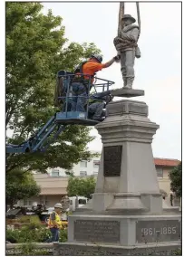 Work­ers from Nab­holz Con­struc­tion on Sept. 2 re­move the Con­fed­er­ate statue from the Bentonville square.