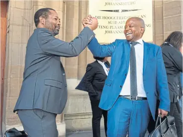 High fives: Lawyer Eric Mabuza, left, and axed Old Mu­tual CEO Peter Moyo cel­e­brate the rul­ing by the high court in Jo­han­nes­burg that or­dered the in­surer to tem­po­rar­ily re­in­state Moyo.