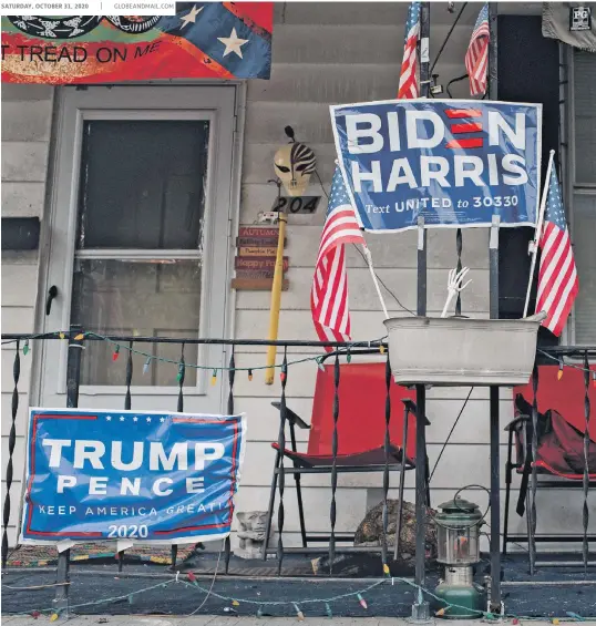 Bi­den and Trump cam­paign signs are shown in front of a home in Free­mans­burg, Pa., on Mon­day.