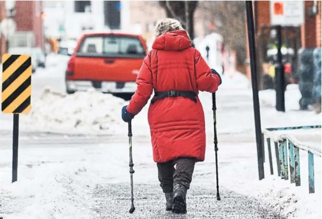 A woman goes for a walk in Montreal on Monday. Much of southern and western Quebec were under weather alerts for prolonged periods of freezing rain with ice pellets throughout the day.