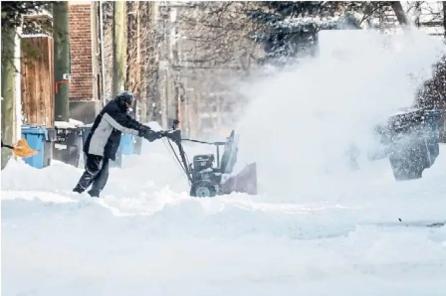 A person clears snow Thursday in Winnipeg after a storm battered the Prairies the night before, triggering power outages and road closures.