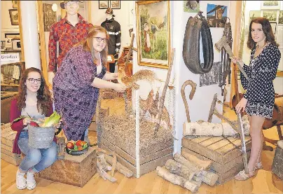 Sum­mer stu­dents at the Glace Bay Her­itage Mu­seum, from left, Amanda Lee, Mar­i­anne Toomey and Tessa MacNeil, look over the early set­tlers Na­tion Build­ing dis­play at the Old Town Hall in cel­e­bra­tion of Canada 150. The mu­seum opens for the sea­son Satur­day...