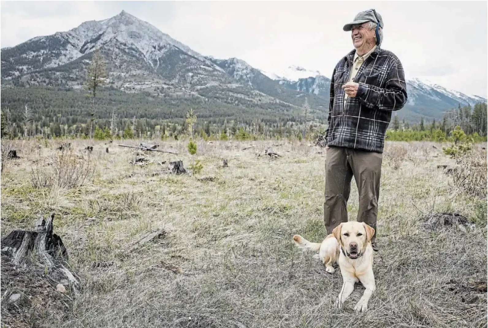 Cliff White, a former Parks Canada fire management coordinator, is shown with his dog Farley in the Carrot Creek fire break in Banff National Park. He says park staff are making good progress on building fire breaks, but more needs to be done.
