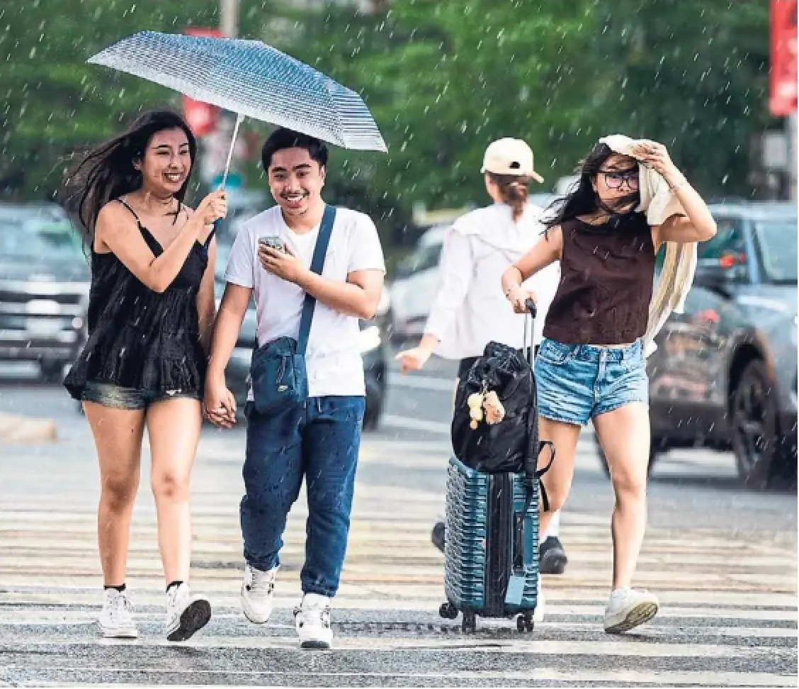 People cross Spadina Street as a sudden sun shower passes through downtown on Tuesday. A 70 per cent chance of precipitation is expected for Wednesday, with a risk of thunderstorms. Full weather map A18