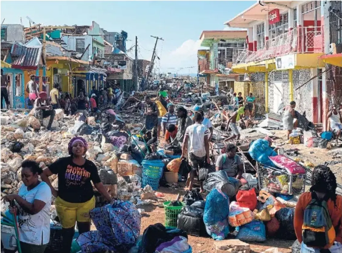 People gather their belongings in the aftermath of Hurricane Melissa in Black River, Jamaica, Thursday. The storm killed 19 on the island.