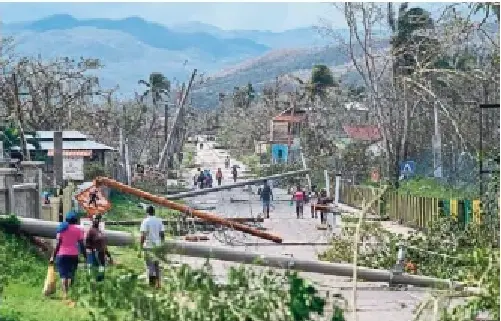 MATIAS DELACROIX/THE ASSOCIATED PRESS FILE PHOTO Res­id­ents walk in Lacovia Tomb­stone, Jamaica, in the after­math of Hur­ricane Melissa last month.