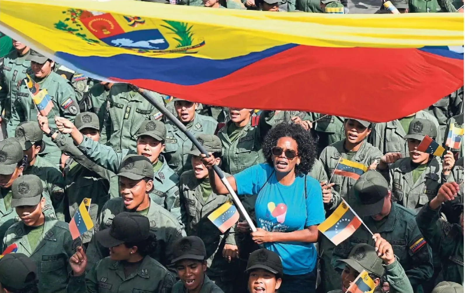 A woman waves a Venezuelan flag during a rally in Caracas on Tuesday. Officials said at least 24 Venezuelan security officers and 32 Cuban military and police were killed in the U.S. operation to capture Nicolás Maduro early Saturday.