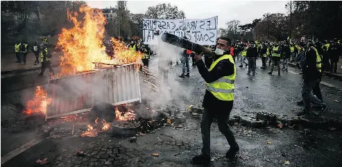 Pro­test­ers build a bar­ri­cade in Paris dur­ing a protest of yel­low vests against ris­ing oil prices and liv­ing costs. The protests are be­ing closely watched in Canada by those who see a par­al­lel be­tween fuel taxes and car­bon taxes.