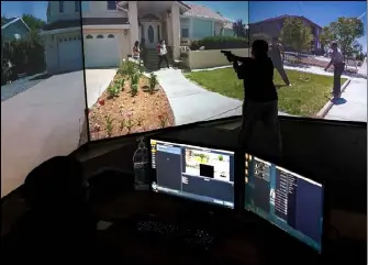 Jes­sica Lopez, a par­tic­i­pant in the Den­ver Po­lice De­part­ment’s women’s com­mu­nity academy, runs through a train­ing sce­nario us­ing a VirTra V-300 video sim­u­la­tor March 21 at the Den­ver Po­lice Academy. Law en­force­ment de­part­ments use the sim­u­la­tor as a train­ing tool for high-pres­sure sit­u­a­tions.