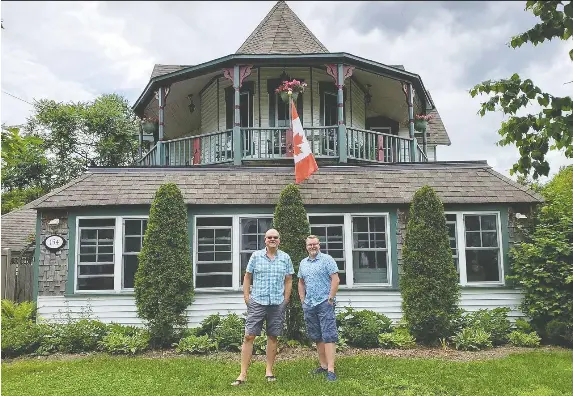 Jim Rud­koski, left, and Derk Goltz in front of their home on Bri­tan­nia Road. The house, with its five-sided ve­randa, was the home of Bri­tan­nia builder Charles Robin­son, who built sev­eral other build­ings in the vil­lage.