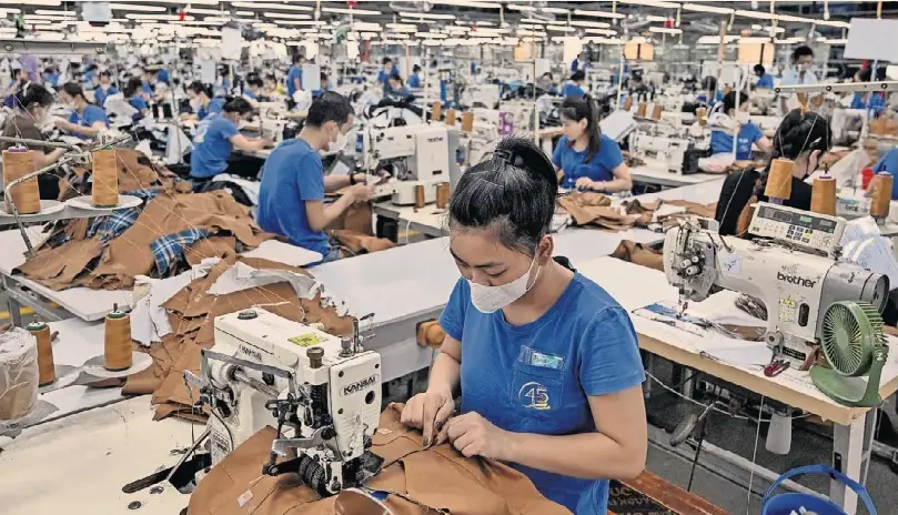 Công nhân tại một nhà máy may ở tỉnh Thái Nguyên, Việt Nam. Quốc gia này, một trong những quốc gia phụ thuộc nhiều nhất vào thương mại thế giới, bán 30% hàng xuất khẩu sang Hoa Kỳ