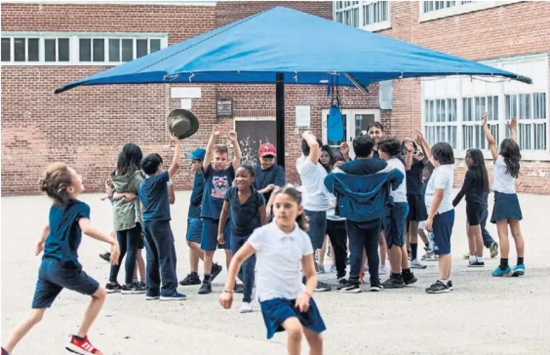 Children at Sts. Cosmas and Damian Catholic School in Toronto helped beat the heat by playing under a new misting station in their yard last June.