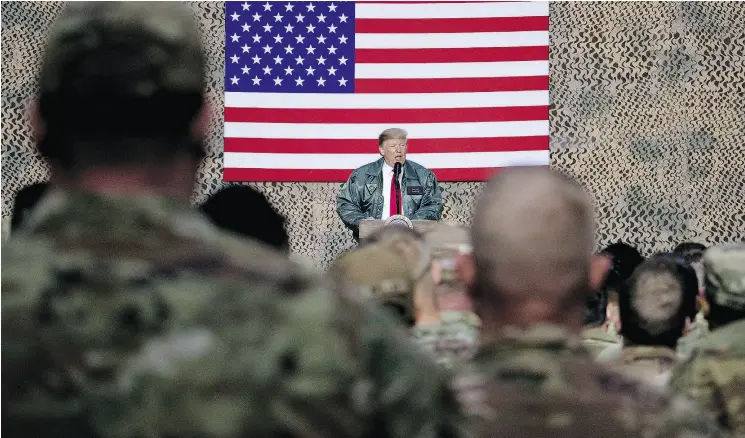 Pres­i­dent Don­ald Trump speaks to mem­bers of the mil­i­tary in De­cem­ber at a hangar rally at Al Asad Air Base, Iraq.